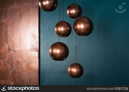 Sphere bronze lamps with turquoise backdrop. Beautiful reflections. Modern interior in blue and brown colors. Christmas and New Year decoration concept. Empty space for your test and design