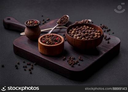 Spice allspice brown color not ground in a wooden saucer on a dark concrete background