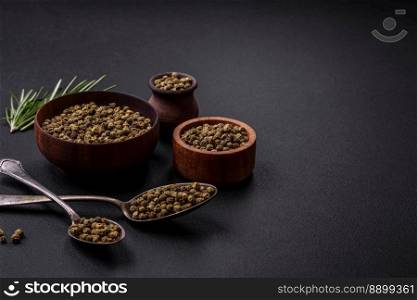 Spice, allspice green in a wooden bowl on a black concrete background. Asian cuisine