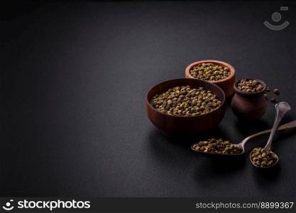 Spice, allspice green in a wooden bowl on a black concrete background. Asian cuisine