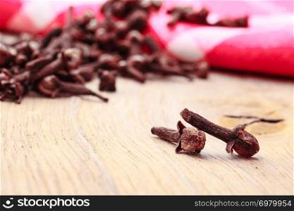 Spice dry cloves heap on kitchen table wooden surface
