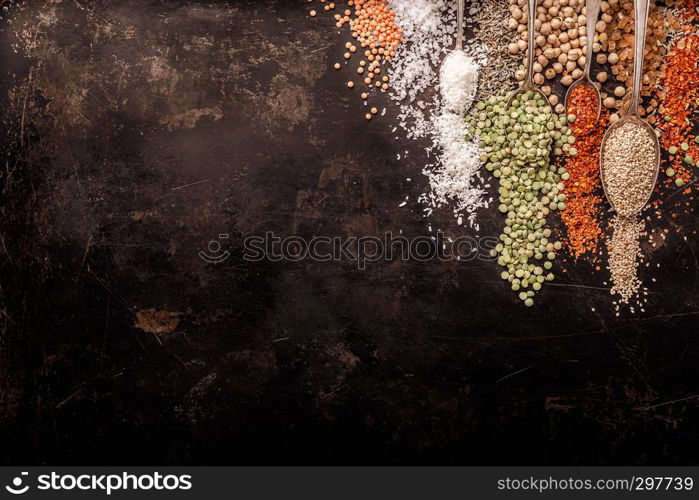 Spices and legumes on black background, top view