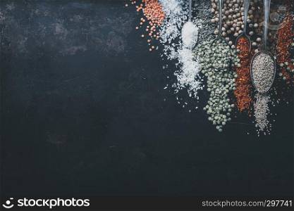 Spices and legumes on black background, top view