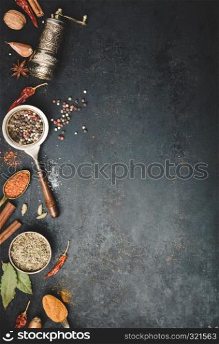 Spices and vintage pepper grinder on dark background, flat lay, space for text. Spices and vintage pepper grinder, flat lay