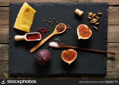 Spices, cheese and figs over slate
