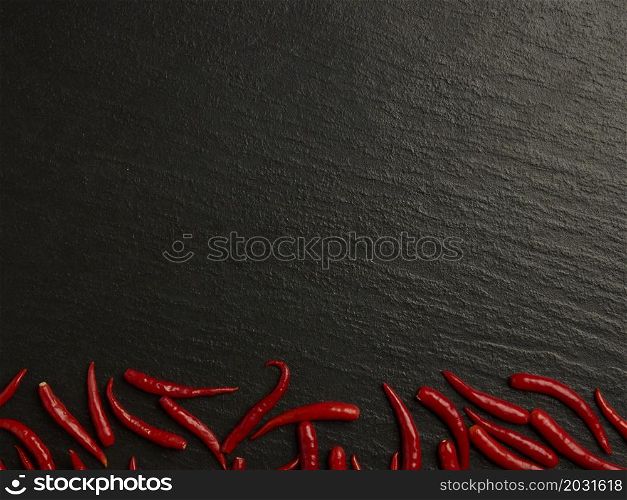 spices concept The hot red chilis organized in their line on the dark background.