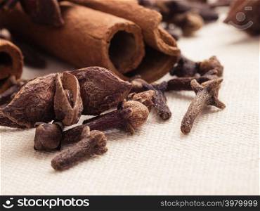 Spices for christmas cakes cinnamon sticks anise stars and cloves on burlap background