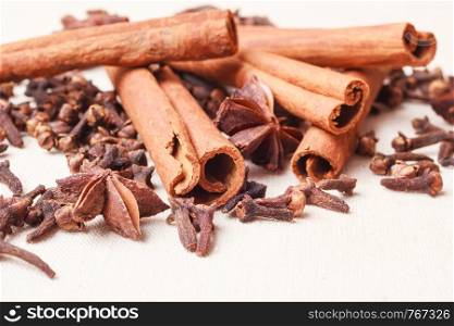 Spices for christmas cakes cinnamon sticks anise stars and cloves on burlap background