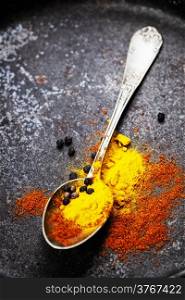 Spices in a spoon with old metal background