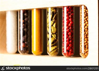 Spices in beakers against dark background