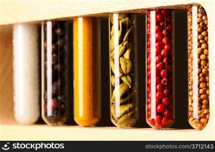 Spices in beakers against dark background