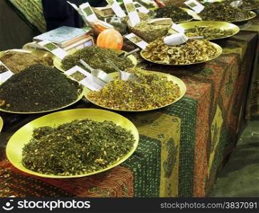 Spices in big plates over table with oriental cloth