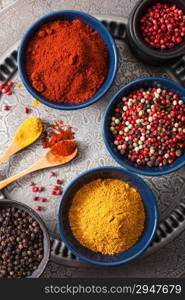 spices in bowls: curry pink and black pepper paprika powder