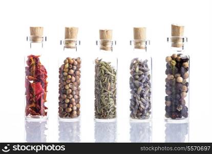 Spices in little bottles isolated on white. Paprika, coriander, rosemary, lavender and peppercorn
