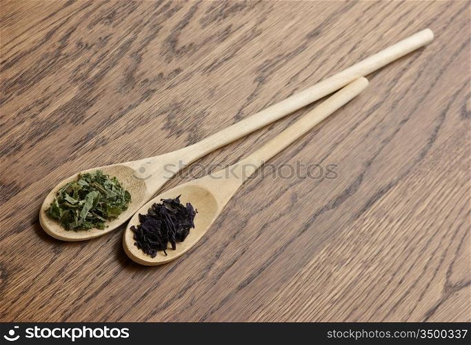 spices in wooden spoons on wooden table