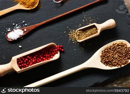 Spices in wooden utensils over slate