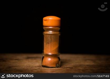 Spices on wooden surface and black background