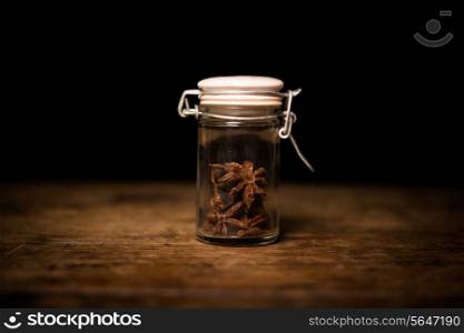 Spices on wooden surface and black background