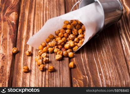 Spicy baked chickpeas in a metal pail on the wooden background. Spicy baked chickpeas