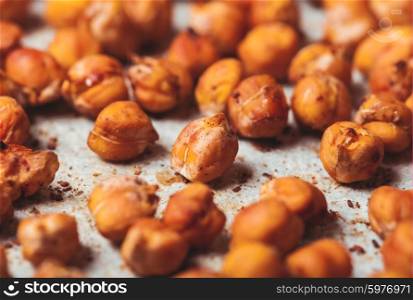 Spicy baked chickpeas scattered on baking paper. Spicy baked chickpeas