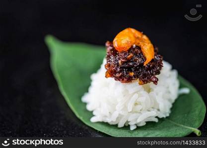 Spicy chili paste with steamed rice on dark background