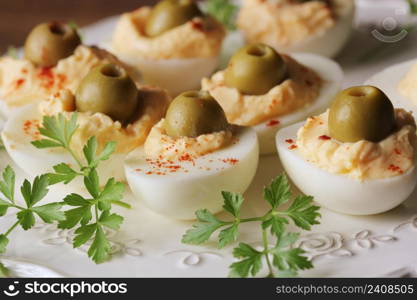Spicy deviled eggs garnished with green olives and parsley .. Spicy deviled eggs garnished with green olives and parsley