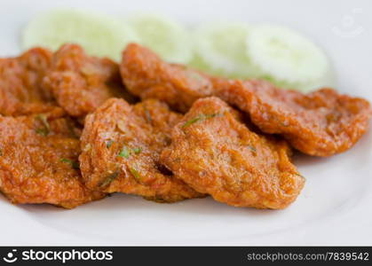 Spicy fried fish cake served with cucumber on plate