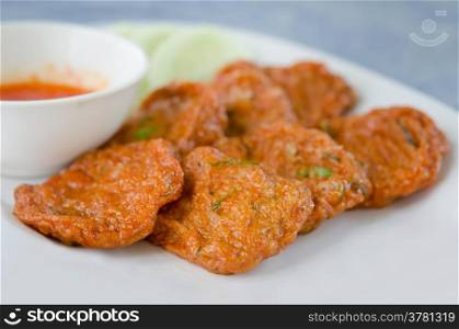 Spicy fried fish cake (Tod Mun Pla) served with cucumber and sweet sauce