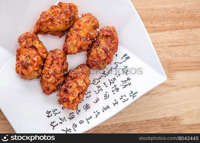 Spicy korean fried chicken with sesame on a plate