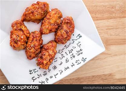 Spicy korean fried chicken with sesame on a plate