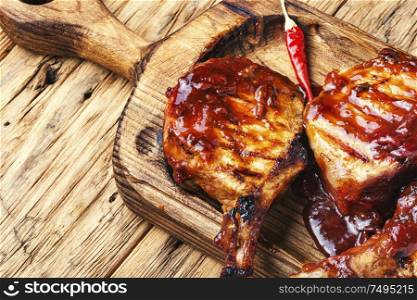 Spicy meat grilled spare ribs on wooden cutting board. Pork ribs in barbecue sauce