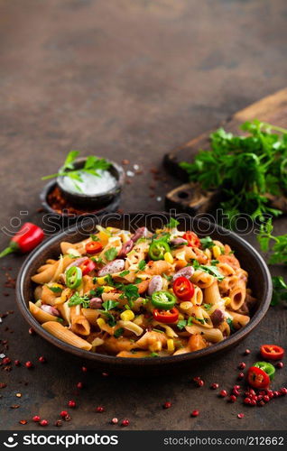 Spicy pasta penne bolognese with vegetables, beans, chili and cheese in tomato sauce