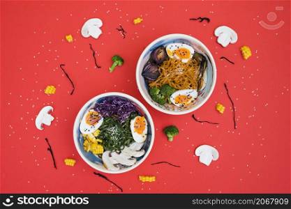 spicy ramen bowls with noodles boiled egg vegetables served with seaweed salad red backdrop