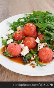 Spicy salad of watermelon balls with arugula and slices of feta