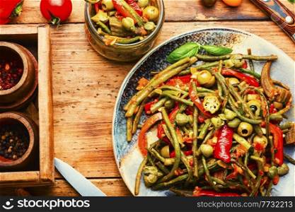 Spicy vegetable appetizer made from pepper, asparagus beans, tomato and capers. Appetizer of stewed vegetables with spices