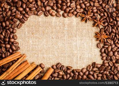 Spilled coffee beans frame with cinnamon and anise