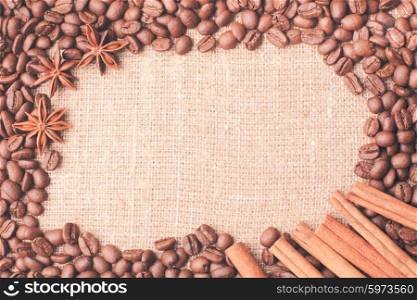 Spilled coffee beans frame with cinnamon and anise. coffee beans frame