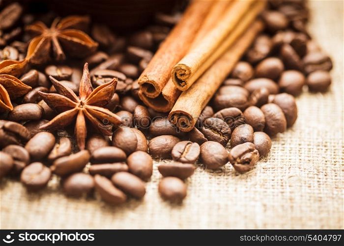 Spilled coffee beans with cinnamon and anise
