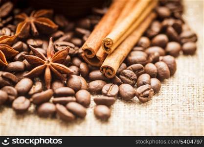Spilled coffee beans with cinnamon and anise