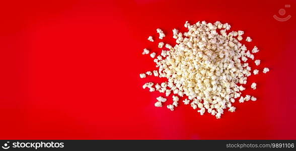 Spilled popcorn on a red background, cinema, movies and entertainment concept