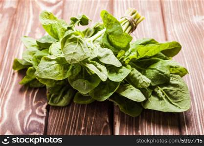 Spinach bunch on the wooden table with copy space. The Spinach bunch