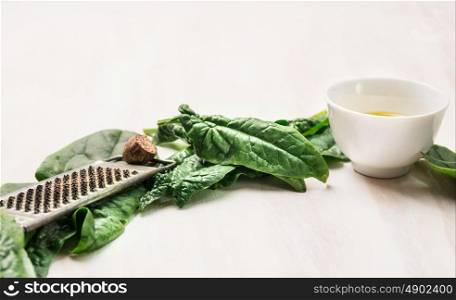 Spinach cooking ingredients on white wooden background