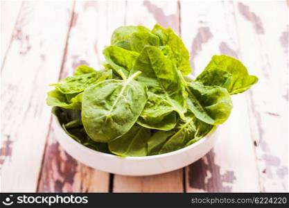 Spinach leaves in a bowl on the table. The spinach leaves