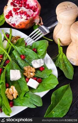 Spinach salad with nuts and apples served on table