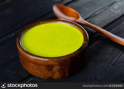 Spinach soup served on wooden board