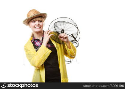 Spinning, angling, cheerful fisherwoman concept. Happy woman in yellow raincoat holding empty fishing keepnet, having fun.. Happy woman holding empty fishing keepnet