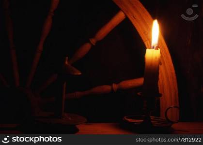 Spinning wheel with candle in dark room