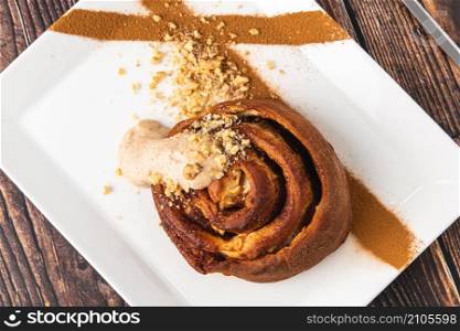 Spiral apple cake or muffin with cup of fresh coffee on wooden background