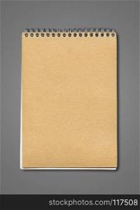 Spiral closed notebook mockup, brown paper cover, isolated on dark grey. Spiral closed notebook mockup