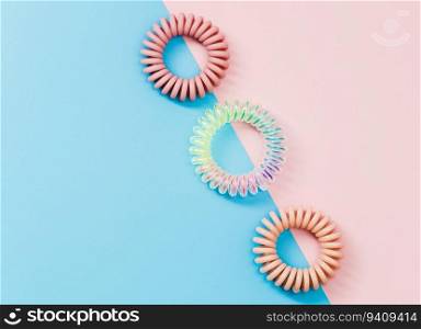 Spiral hair rubber bands on the pastel colour background for feminine accessories concept